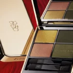 Per l’autunno 2025, Maison Guerlain celebra il grande spettacolo della natura con la nuova collezione in edizione limitata Majestic Feathers. I prodotti make-up iconici firmati Guerlain - Rouge G, Ombres G, Terracotta e Météorites - sono impreziositi da eleganti decorazioni colorate che evocano la magia delle maestose piume dei volatili. La linea Rouge G si arricchisce di: • 3 nuove cover gioiello • Songbird, un morbido sfondo color palissandro arricchito da sfumature bianche e bordeaux e dettagli dorati. • Phoenix, ispirata alle piume della fenice, questa combinazione audace unisce il rosso intenso a un beige delicato, illuminato da sfumature dorate. • Peacock, richiamando le piume iridescenti del pavone, è caratterizzata da una variazione di blu e verdi intensi e luminosi, che si intrecciano attorno a una linea ondulata dorata. • 8 nuove shade Rouge G Velvet, composte all'81% da principi attivi idratanti e leggermente desaturate grazie all’aggiunta di un tocco di pigmento nero. Due esclusive palette Ombres G si uniscono alla collezione, presentando quattro finish differenti per un effetto multidimensionale. • Ombres G 870 Emerald Feather: una combinazione di tonalità naturali, dal verde profondo all’oro luminoso. • Ombres G 131 Birdy Beige: un'armonia che celebra le tonalità marroni e rosate, per uno sguardo dall'eleganza senza tempo. L’iconica Terracotta Light, formulata con il 96% di ingredienti di origine naturale, viene rinnovata nella versione Terracotta Peacock: la base della poudre bronzante è impreziosita da un motivo ispirato alle piume di pavone, che fonde due tonalità di blush con un tocco dorato. Le Météorites Phoenix, perle di poudre rivelatrici di luminosità, create per questa edizione limitata, presentano due nuove tonalità dai toni vivaci, un rosa magenta e un beige nude, per fissare e opacizzare l’incarnato, sublimandolo con un glow unico. Il packaging dorato, come la cover Rouge G, presenta la stampa color rosso intenso e beige delicato, ispirata alle maestose piume della Fenice. Guerlain, inoltre, ha creato un set d’eccezione: Rouge G Prestige, realizzata in collaborazione con l’atelier parigino Baqué Molinié, abbinata a 3 shade iconiche. La cover gioiello è decorata da un’elegante tonalità nera opaca, sormontata da una piuma ricamata e intrecciata a ricami dorati e perline rosse luminose.